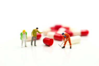 Minyatür insanlar: kapsül ilacı üzerinde çalışan adam sağlıklı olarak kullanıyor.