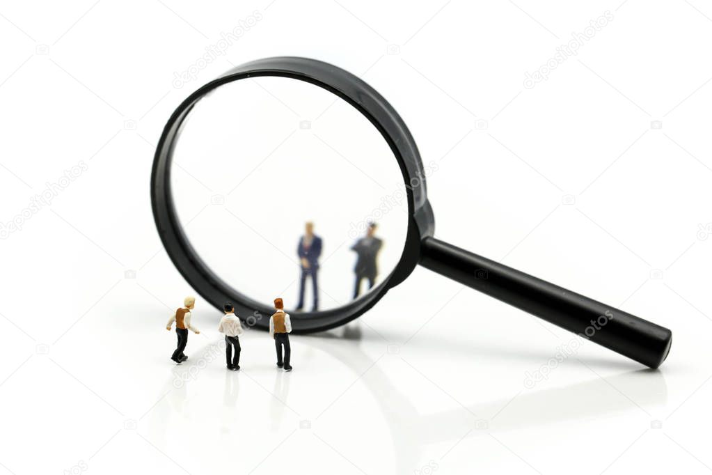 Miniature people : Successful businessman with magnifying glass 