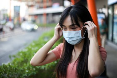 Beautiful asia woman wearing mouth mask against air smog polluti