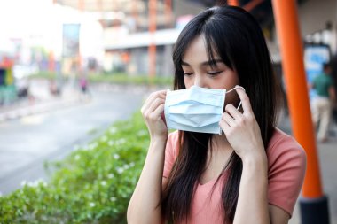 Beautiful asia woman wearing mouth mask against air smog polluti