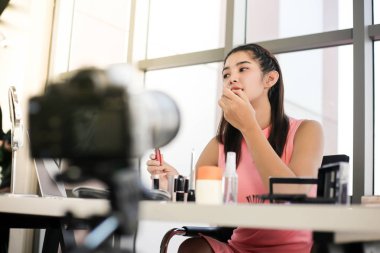 Asyalı kadın güzellik blogcusu veya vlogger incelemesi kozmetik ürünü Çevrimiçi kız sosyal medya pazarlaması.