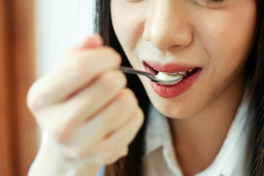 Kahve dükkanında tatlı yiyen güzel bir kadını kapat..