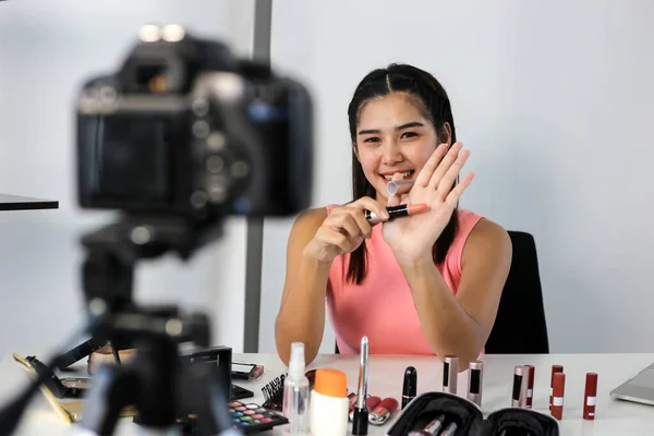 Asyalı kadın güzellik blogcusu veya vlogger incelemesi kozmetik ürünü Çevrimiçi kız sosyal medya pazarlaması.