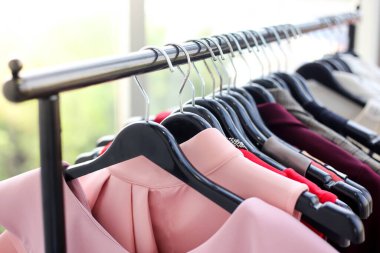 Giysileri kapatın ve tasarımcı giysi mağazasında bir rafa asın. odak noktası.