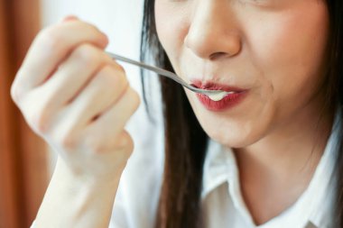 Kahve dükkanında tatlı yiyen güzel bir kadını kapat..