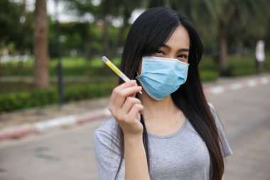Yüz koruması takan Asyalı kadın termometre sıcaklığı ölçümü, virüs maskesi, koronavirüsten hastalık ve sağlık sigortası, kovid19, seçici odak noktası.