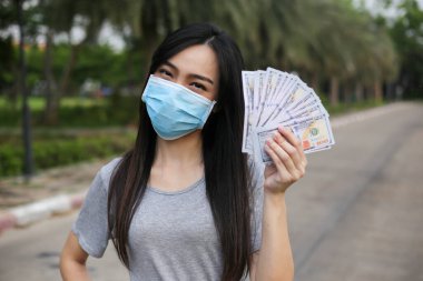 Yüz koruması takan Asyalı kadın, Virüs maskesi para ve kredi kartı problemi, Coronavirus sırasında ekonomik kriz, Covid-19 pandemisi