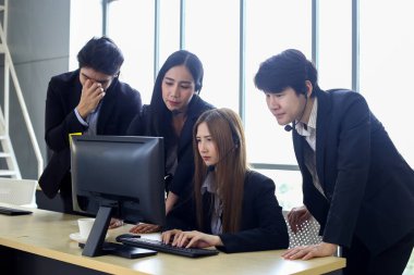 Asya Çağrı Merkezi çalışanlarından oluşan bir grup veya ofiste kulaklığı olan kendine güvenen iş adamları.