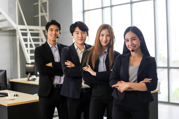 アジアコールセンターの労働者やオフィスでヘッドセットを持つ自信のビジネスチームのグループ — ストック写真