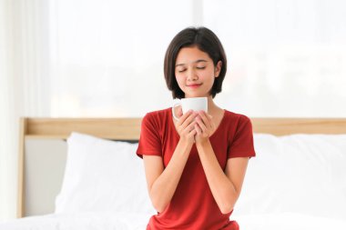 Mutlu çift Asyalı kadın sabah kahvesi, taze çay ya da yatakta sıcak süt ile birlikte eğleniyor..