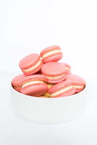 Macaron rosa en un plato blanco sobre un fondo blanco aislado —  Fotos de Stock