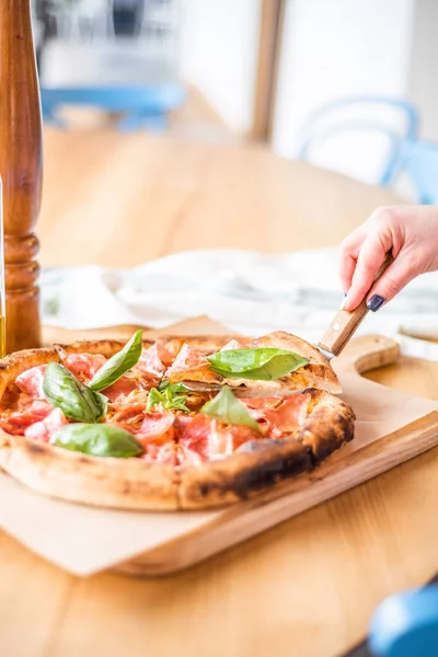 Delicious pizza stands on the table, pizza with red sauce, pancetta and basil, Italian cuisine, pizzeria — 图库照片
