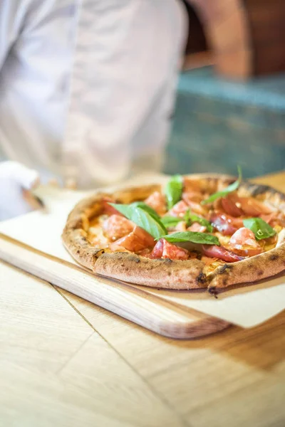 Delicious pizza stands on the table, pizza with red sauce, pancetta and basil, Italian cuisine, pizzeria — 图库照片