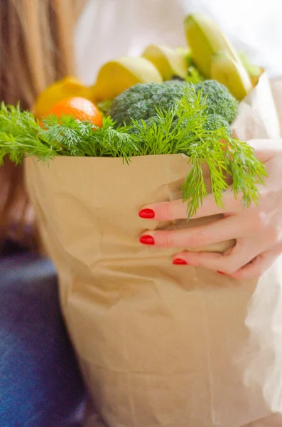 Wanita memegang paket dengan sayuran di tangan — Stok Foto
