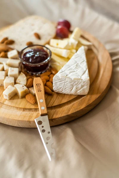 Cheese plate served with nuts, Top view. Assorted cheeses Camembert, Brie, Parmesan blue cheese, goat — Stock Photo, Image