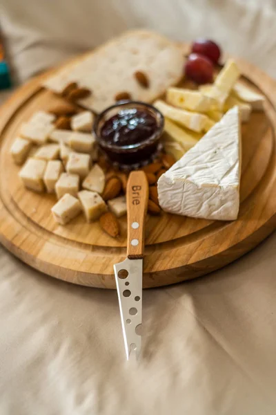 Cheese plate served with nuts, Top view. Assorted cheeses Camembert, Brie, Parmesan blue cheese, goat — Stock Photo, Image