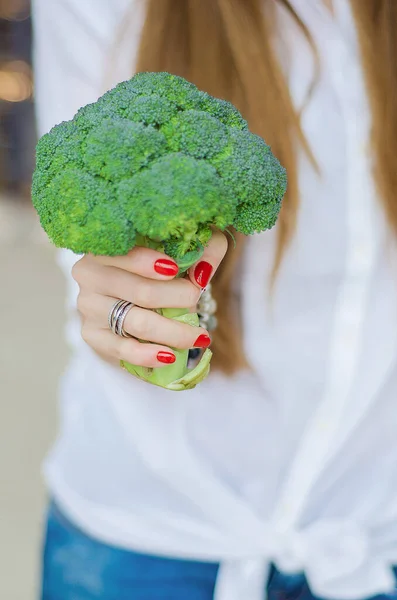 Récolte de brocoli frais et gros. La fille tient la récolte dans ses mains . — Photo
