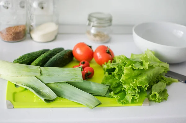 Mangkuk dengan salad dan sayuran segar di meja dapur. Makanan sehat — Stok Foto