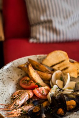 Bir restoranda bir tabakta çeşitli deniz ürünleri duruyor.