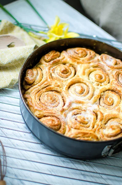 The concept of American cuisine. Pastries and desserts. Cinnabon with cinnamon and white glaze. Buns with cinnamon and cream cheese on a light background.