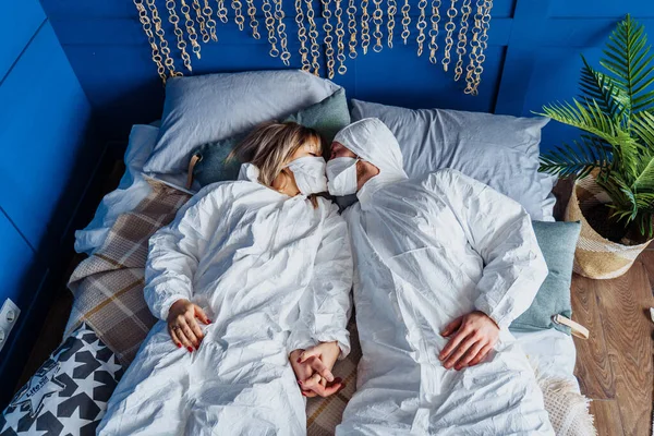 Twee Mensen Beschermende Pakken Gezichtsmaskers Liggend Het Bed Elkaar Kussen — Stockfoto