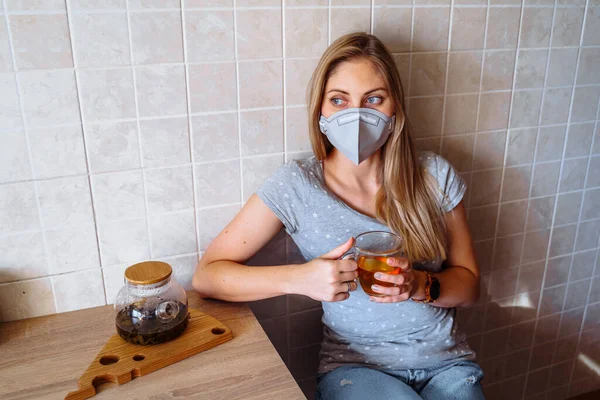 Menina Triste Sentado Cozinha Uma Máscara Protetora Beber Chá Isolado — Fotografia de Stock