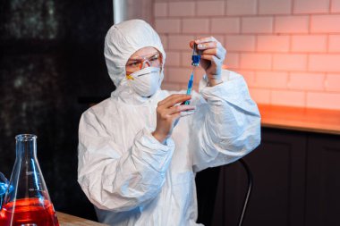 Coronavirus aşısı geliştirme. Biyokimya laboratuarı araştırmaları için bilimsel ve tıbbi laboratuvar enstrümanı. Kimyager laboratuvarda kimyasal sıvı şırıngası ile numune analiz ediyor.