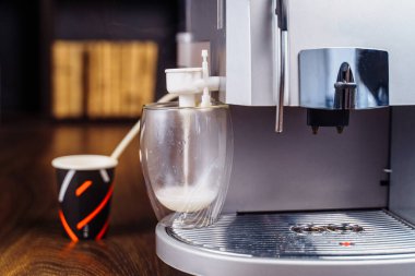 Süt köpüğünü kapuçino, ısıtma ve kırbaçlama için hazırlama süreci. Kahve için makine süt çırpar. Küçük işletme kavramı