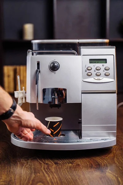 The budget model of the coffee machine prepares a delicious, fragrant espresso. Freshly brewed coffee is poured from the coffee machine into cup in the kitchen at home