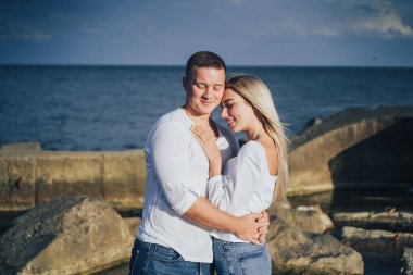 Sevgi dolu çift eğleniyor. Gülüyorlar, sarılıyorlar ve sıcak yaz akşamlarının tadını çıkarıyorlar. Romantik bir çift güneşin altın ışıklarıyla kıyıda durur ve birlikte vakit geçirir, çöllerin tadını çıkarırlar.