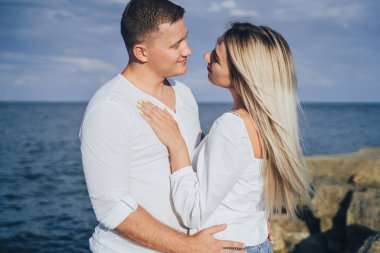 Sevgi dolu çift eğleniyor. Gülüyorlar, sarılıyorlar ve sıcak yaz akşamlarının tadını çıkarıyorlar. Romantik bir çift güneşin altın ışıklarıyla kıyıda durur ve birlikte vakit geçirir, çöllerin tadını çıkarırlar.