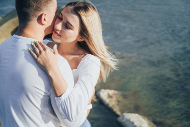 Sevgi dolu çift eğleniyor. Gülüyorlar, sarılıyorlar ve sıcak yaz akşamlarının tadını çıkarıyorlar. Romantik bir çift güneşin altın ışıklarıyla kıyıda durur ve birlikte vakit geçirir, çöllerin tadını çıkarırlar.