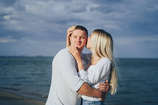 海を背景に彼氏と抱擁魅力的な若い女性 海の近くに立って幸せなカップルの屋外写真 夏休みのコンセプト カジュアルスタイル 一緒に幸せだ 屋外撮影 — ストック写真