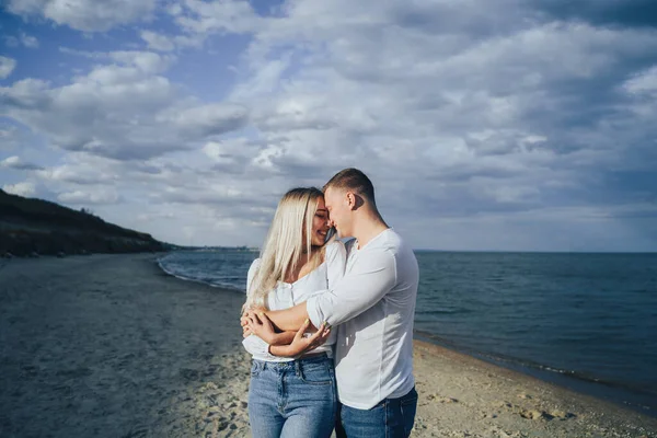 海を背景に彼氏と抱擁魅力的な若い女性 海の近くに立って幸せなカップルの屋外写真 夏休みのコンセプト カジュアルスタイル 一緒に幸せだ 屋外撮影 — ストック写真
