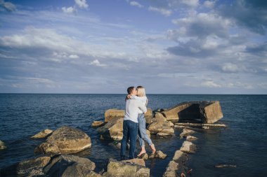 Sevgi dolu çift eğleniyor. Gülüyorlar, sarılıyorlar ve sıcak yaz akşamlarının tadını çıkarıyorlar. Romantik bir çift güneşin altın ışıklarıyla kıyıda durur ve birlikte vakit geçirir, çöllerin tadını çıkarırlar.