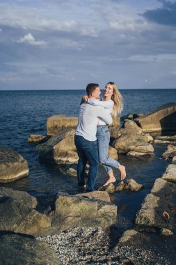 Sevgi dolu çift eğleniyor. Gülüyorlar, sarılıyorlar ve sıcak yaz akşamlarının tadını çıkarıyorlar. Romantik bir çift güneşin altın ışıklarıyla kıyıda durur ve birlikte vakit geçirir, çöllerin tadını çıkarırlar.