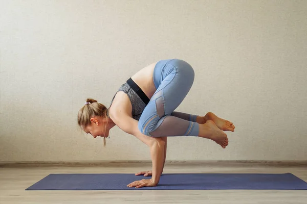Woman doing yoga at home online (sports exercises), have fun, spending good time. Concept of a healthy lifestyle. quarantined sports life and online studying. Different difficult yoga poses