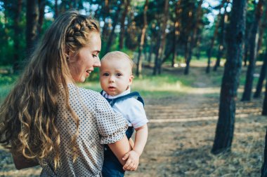 Açık havada eğlenen komik bir ailenin portresi. Macera, seyahat, turizm, yaşam tarzı konsepti. Her hafta sonu birlikte vakit geçirmek. Aile zamanı. Anne babası ve bir yaşındaki oğlu.