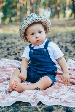 Sarışın, beyaz, komik bir çocuğun yakın plan portresi ormanda ailesiyle vakit geçiren. Ciddi bir çocuk, ebeveyn eğlencesi konusunda şüpheci. Gülümsemek istemiyor.