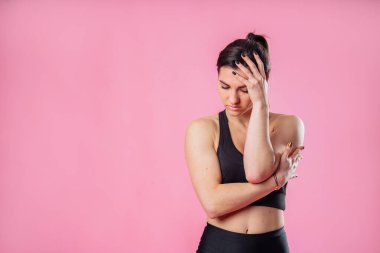 Mutsuz üzgün kadının portresi yüzünü buruşturur, ağlamak üzere olan, amacına ulaşamadığı için mutsuz olan, pembe stüdyo arka planında izole edilmiş. Üzgün kızın başı ağrıyor. Yüzüne ve kafasına dokunuyor.