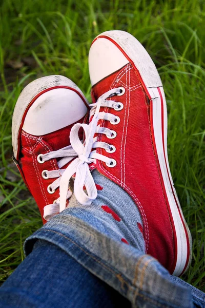 Feet in dirty red sneakers outdoors. — Stock Photo, Image