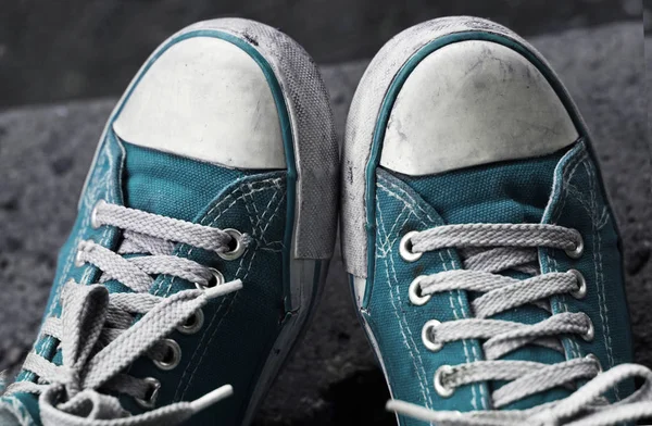 Pies en zapatillas azules sucias y jeans al aire libre . — Foto de Stock