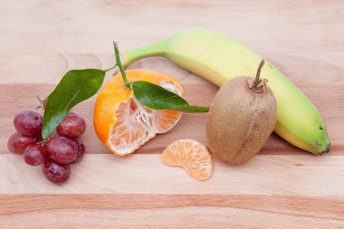 yarım mandalina ve tatlı üzüm ve muz, kivi