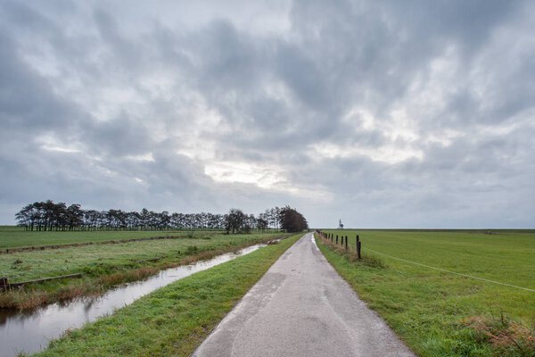 hiking trail next to the meadow with Stratus Clouds