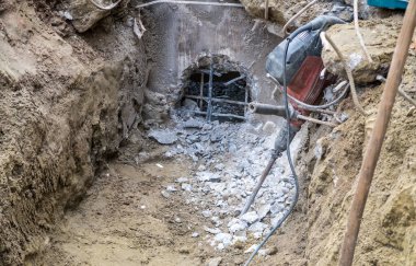 Beton bir lağım çukurunda delik açmak.