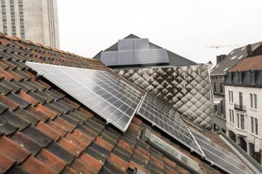 Konut alanındaki bir binada, çatıda güneş panelleri var.