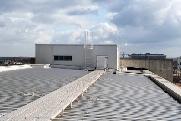 on an aluminum roof with safety cables on a big building