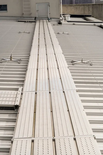 on an aluminum roof with safety cables on a big building