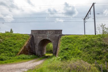 Bu eski tuğla köprü rayların altında elektrik kablolarıyla