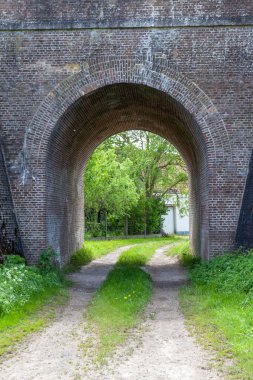 Bu eski tuğla köprünün altında toprak bir yol var.